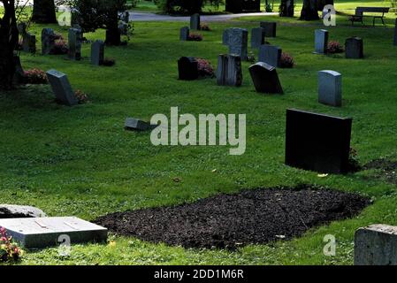 Das neu gegrabene Grab auf dem Friedhof im Sommer. Stockfoto