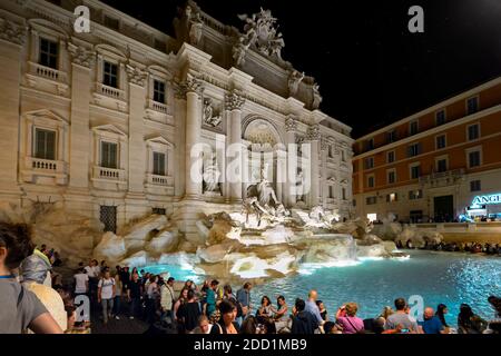 Abends Blick auf den beleuchteten Trevi-Brunnen von Bernini entworfen voll mit Touristen in der Altstadt von Rom Italien. Stockfoto