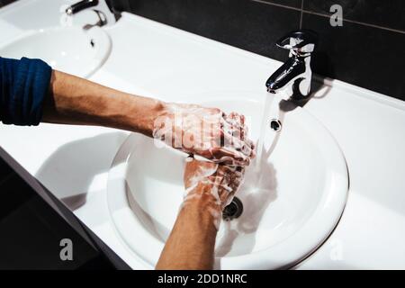 Nahaufnahme. Der Mensch wäscht sich vorsichtig die Hände mit Seife Stockfoto