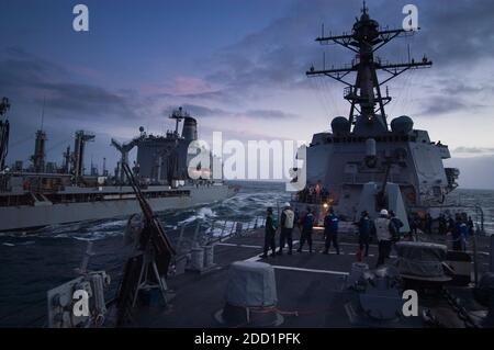 Während die Nacht hereinbricht, zieht USS Roosevelt eine unterwegs-Auffüllung (UNREP) von USNS Patuxent vor der Westküste Schottlands aus. USS Roosevelt (DDG-80) ist ein Zerstörer der Arleigh Burke-Klasse im Dienst der US Navy. Sie wird zu Ehren von Präsident Franklin D. Roosevelt und seiner Frau, der damaligen First Lady Eleanor Roosevelt, benannt. Dieses Schiff ist der 30. Zerstörer ihrer Klasse. Stockfoto