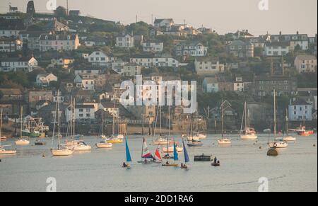 Kleine bunte Segelboote werden im Hafen im Fischerdorf Polruan, Cornwall, England, gesegelt. Stockfoto