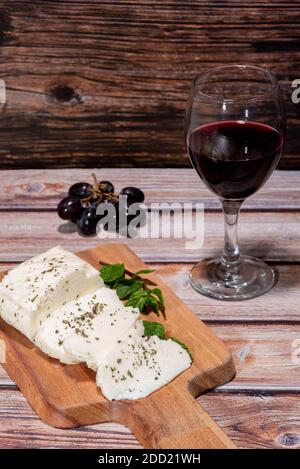 Traditionelle zyprische Halloumi Käse, Rotwein und Trauben auf einem Tisch Stockfoto