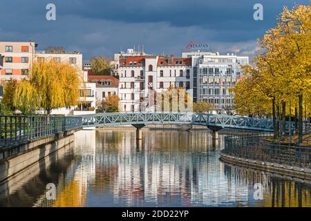 Berlin, Deutschland - 24. Oktober 2020: Hafenbecken Tegeler Hafen mit alten und modernen Gebäuden, Wohneinheiten, Fußgängerbrücke und herbstfarbenem Baum Stockfoto