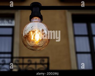 Eine Glühbirne. Eine Glühbirne, die an einem elektrischen Kabel hängt. Stockfoto