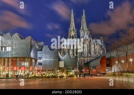 Nachtszene auf dem Heinrich-Böll-Platz in Köln, Deutschland mit dem Kölner Philarmonie-Saal und dem Ludwig-Museum, das vom majestätischen Kölner C überragt wird Stockfoto