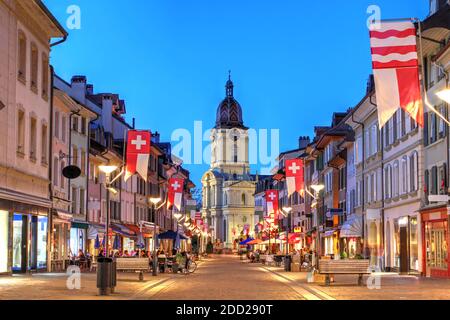 Nachtszene entlang der Grand Rue in Morges, Schweiz, mit Temple de Morges im Hintergrund. Stockfoto