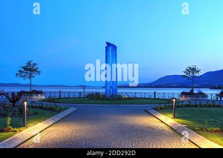 Sonnenuntergang auf der Esplanade de Mont Blanc in Neuchatel, Schweiz mit einem Kunstwerk des Schweizer Künstlers Rene Kueng Stockfoto