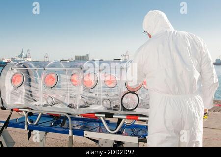 Medizinischer Mann mit Krankenwagen Bett isoliert für Virus oder nukleare Alarm Stockfoto