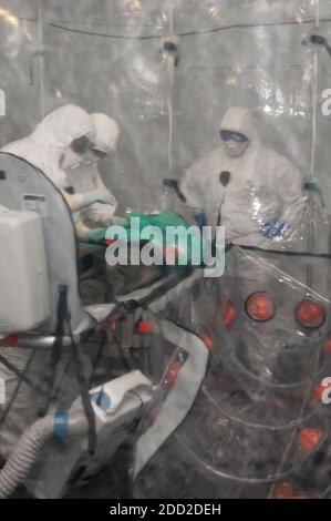 Medizinische Menschen mit Krankenwagen Bett für ebola, covid oder Pandemie Stockfoto