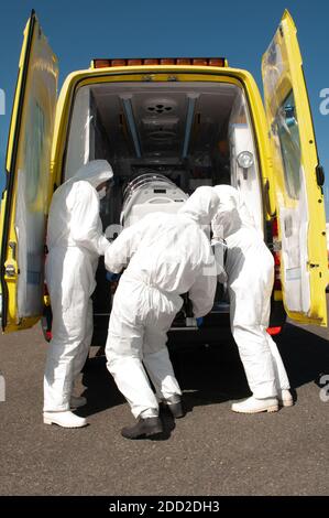 Gruppe von medizinischen Personen mit Krankenwagen Bett für ebola, covid oder Pandemie Stockfoto