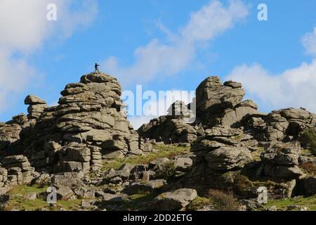 Kletterer genießen die Herausforderung des Hound Tor im Dartmoor National Park, Devon, England. Dieses zerklüftete Tor ist aus einem alten Granitfelsen gefertigt. Stockfoto