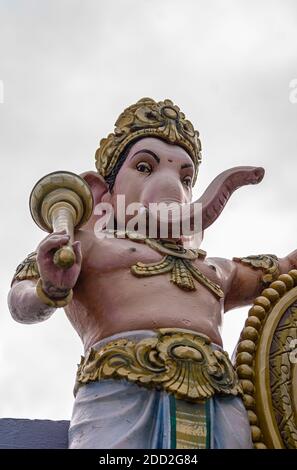 Kadirampura, Karnataka, Indien - 4. November 2013: Sri Murugan Tempel. Farbenfrohe Nahaufnahme des Gesichts von Ganesha gegen silbernen Himmel. Stockfoto