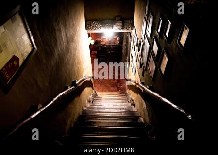 VILLA GESELL, ARGENTINIEN, 14. NOVEMBER 2019: Dramatische Sicht auf die schaurige Treppe von oben in die Dunkelheit des Innenraums des alten Pubs Stockfoto