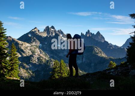 WA18453-00...WASHINGTON - Wanderer in der Nähe von Spektakel Point mit Chikamin Ridge und Lemah Mountain im Hintergrund in der Alpine Lakes Wilderness Area. Stockfoto