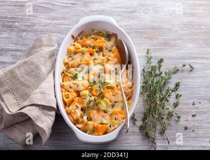 Kürbisgratin mit Lauch, Thymian und Käse auf grauem Hintergrund, selektiver Fokus Stockfoto