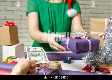 Zahlung für Geschenkverpackung bei der Verpackung mit USA-Dollar-Banknoten. Stockfoto