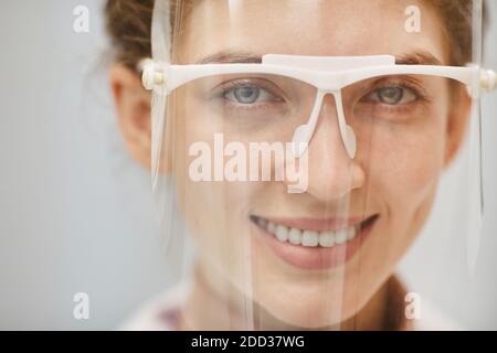 Nahaufnahme der Ärztin in Schutzmaske und Brille lächelnd Bei der Kamera Stockfoto