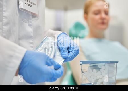 Nahaufnahme des Zahnarztes in Schutzhandschuhen, die das Paket mit öffnen Medizinische Instrumente vor dem medizinischen Eingriff Stockfoto