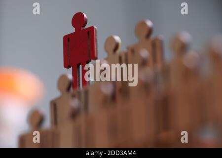 Roter Spielzeugmann aus Holz, der aus nächster Nähe über anderen steht Stockfoto