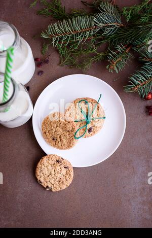 Neujahrskekse mit Schokoladenstücken und frischer Milch in einer Glasflasche mit Tube. Flach liegend Stockfoto