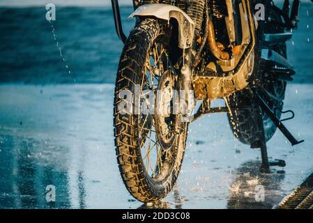 Waschserie für Motorräder. Ein Motorrad bei einer Autowäsche bei Sonnenuntergang waschen Stockfoto