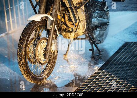 Waschserie für Motorräder. Ein Motorrad bei einer Autowäsche bei Sonnenuntergang waschen Stockfoto