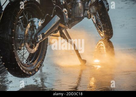 Waschserie für Motorräder. Ein Motorrad bei einer Autowäsche bei Sonnenuntergang waschen Stockfoto