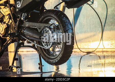 Waschserie für Motorräder. Ein Motorrad bei einer Autowäsche bei Sonnenuntergang waschen Stockfoto