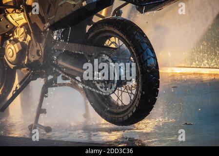 Waschserie für Motorräder. Ein Motorrad bei einer Autowäsche bei Sonnenuntergang waschen Stockfoto