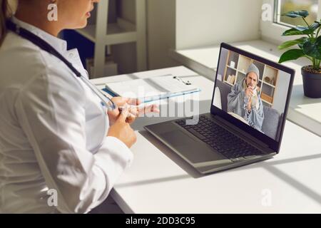 Frau Arzt in der medizinischen Uniform sagen Empfehlung für junge Kranke Mann Patient online Stockfoto
