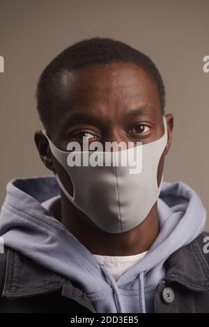 Nahaufnahme eines afrikanischen jungen Mannes, der vor der Kamera in Schutzkleidung posiert Maske Stockfoto