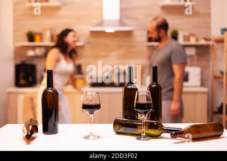 Ein Paar, das nach der Hochzeit eine romantische Nacht in der Küche mit Rotwein hatte. Stockfoto