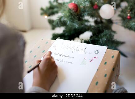 Kind schreibt Weihnachten Wunschliste während Corona Krise in Isolation Stockfoto