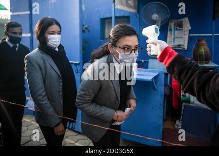 Kathmandu, Nepal. Dezember 2020. Ein Schulpersonal, das die Körpertemperatur eines Schülers an der Saipal Akademie mit einer Thermopistole überprüft, um die Ausbreitung von covid-19 vor den Prüfungen zu verhüten. Der Nationale Prüfungsausschuss hat alle Schulen beauftragt, einen Gesundheitsschalter einzurichten, der die soziale Distanzierung an den Schulen überwacht. Das Protokoll entwickelte auch Zwangsmasken für Schüler, Lehrer und Mitarbeiter des Prüfungszentrums. Ebenso wird jeder Schüler mindestens zwei Meter voneinander entfernt platziert. Kredit: SOPA Images Limited/Alamy Live Nachrichten Stockfoto