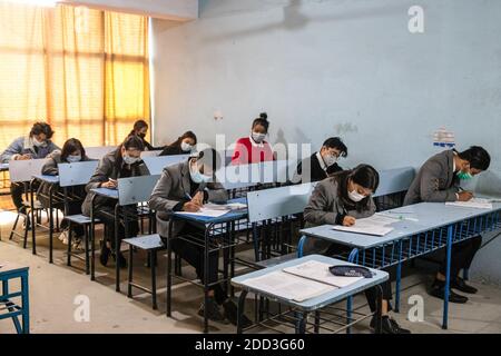 Kathmandu, Nepal. Dezember 2020. Schüler tragen Gesichtsmasken als vorbeugende Maßnahme gegen die Ausbreitung von covid-19 an der Saipal Akademie während der Prüfungen. Der Nationale Prüfungsausschuss hat alle Schulen beauftragt, einen Gesundheitsschalter einzurichten, der die soziale Distanzierung an den Schulen überwacht. Das Protokoll entwickelte auch Zwangsmasken für Schüler, Lehrer und Mitarbeiter des Prüfungszentrums. Ebenso wird jeder Schüler mindestens zwei Meter voneinander entfernt platziert. Kredit: SOPA Images Limited/Alamy Live Nachrichten Stockfoto