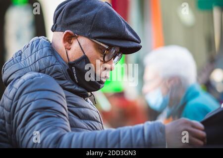 London, Großbritannien - 3. November 2020 - EIN schwarzer Mann, der beim Einkaufen auf dem Walthamstow Markt eine Gesichtsmaske trägt, falsch, falsches Tragen Stockfoto