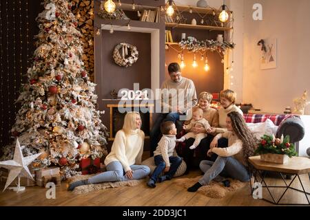 Multi Generation Familie in der Nähe von Weihnachtsbaum in dekorierten Haus, glückliches neues Jahr 2021 Stockfoto