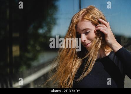 Porträt einer jungen Frau mit roten Haaren im Freien in der Stadt. Speicherplatz kopieren. Stockfoto