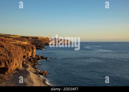 Wilder Strand in der Nähe von Playa San Juan bei Sonnenuntergang, erhöhter Blick auf die Bananenplantagen auf der Spitze der rauen Klippen, Teneriffa, Kanarische Inseln, Spanien Stockfoto