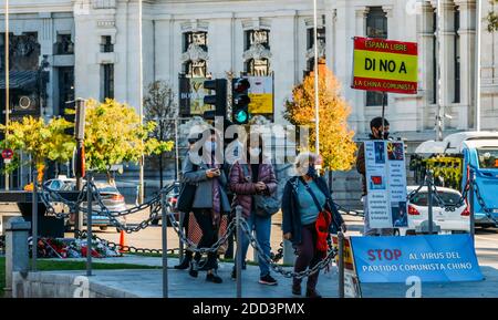 Madrid, Spanien - 21 2020. November: Ein Mann hält ein Zeichen aus Protest vor den Cibeles gegen China für die Verbreitung von Covid-Lügen. Verschwörungstheorie Stockfoto