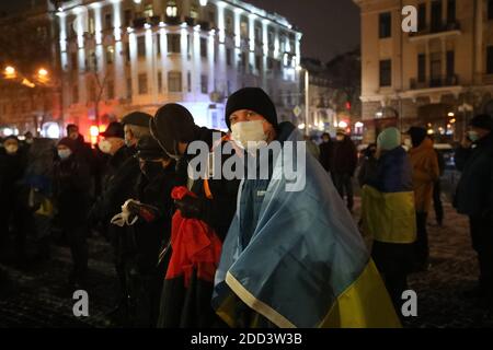 Non Exclusive: CHARKIW, UKRAINE - 21. NOVEMBER 2020 - EIN Mann mit ukrainischer Flagge nimmt an einer Kundgebung zum siebten Jahrestag der Revolte Teil Stockfoto