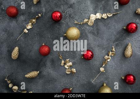 Weihnachtliche Komposition mit goldener und roter Kugel-Dekoration auf dunklem Hintergrund. Flach liegend, Draufsicht Stockfoto