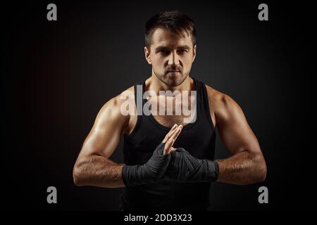 Muskulös sportlich schöner Mann im Boxverband auf schwarzem Hintergrund Stockfoto