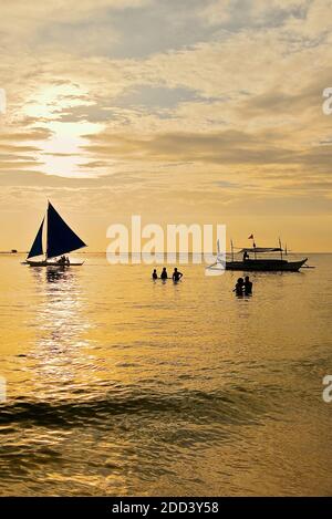 Silhouette von zwei Booten und Touristen bei einem goldenen Sonnenuntergang am Weißen Strand auf Boracay Island, Aklan Provinz, Visayas, Philippinen, Asien Stockfoto