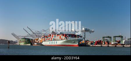 Schiffe aus China im Hafen von Oakland, von Alameda aus gesehen, Kalifornien. Das Schiff mit der Marke COSCO gehört zur chinesischen Overseas Shipping Corp Stockfoto