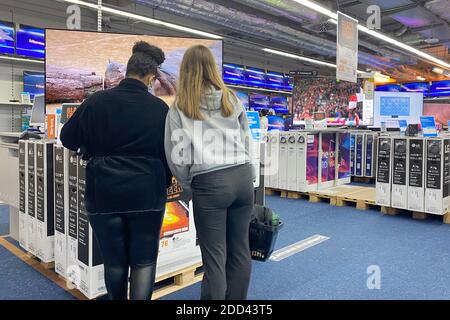 München, Deutschland. November 2020. Zwei junge Frauen stehen vor einem Fernseher. TV-Geräte in einem Saturn Elektronik-Shop, OLED, Shop. Quelle: dpa/Alamy Live News Stockfoto