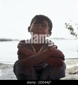 Jungen Hocken bin Strang Bei Canaima Venezuela 1966. Jungs hocken am Strand in der Nähe von Canaima (Venezuela), 1966. Stockfoto