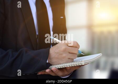 Nahaufnahme des Geschäftsmannes Hand Schreiben einer Notiz an Geschäftsdokument, Unterzeichnung Vertrag, Partnerschaftsvereinbarung. Stockfoto