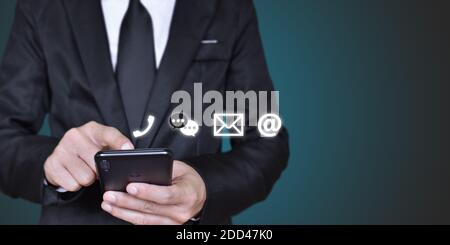 KONTAKTIEREN Sie uns, Geschäftsmann Hand hält Handy mit Symbol (Mail, Adresse, Anruf) Stockfoto