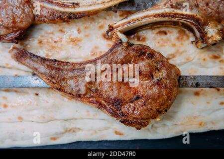 Gegrilltes oder gegrilltes Lammfleisch hacken Fleischsteaks auf schwarzem Hintergrund. Stockfoto